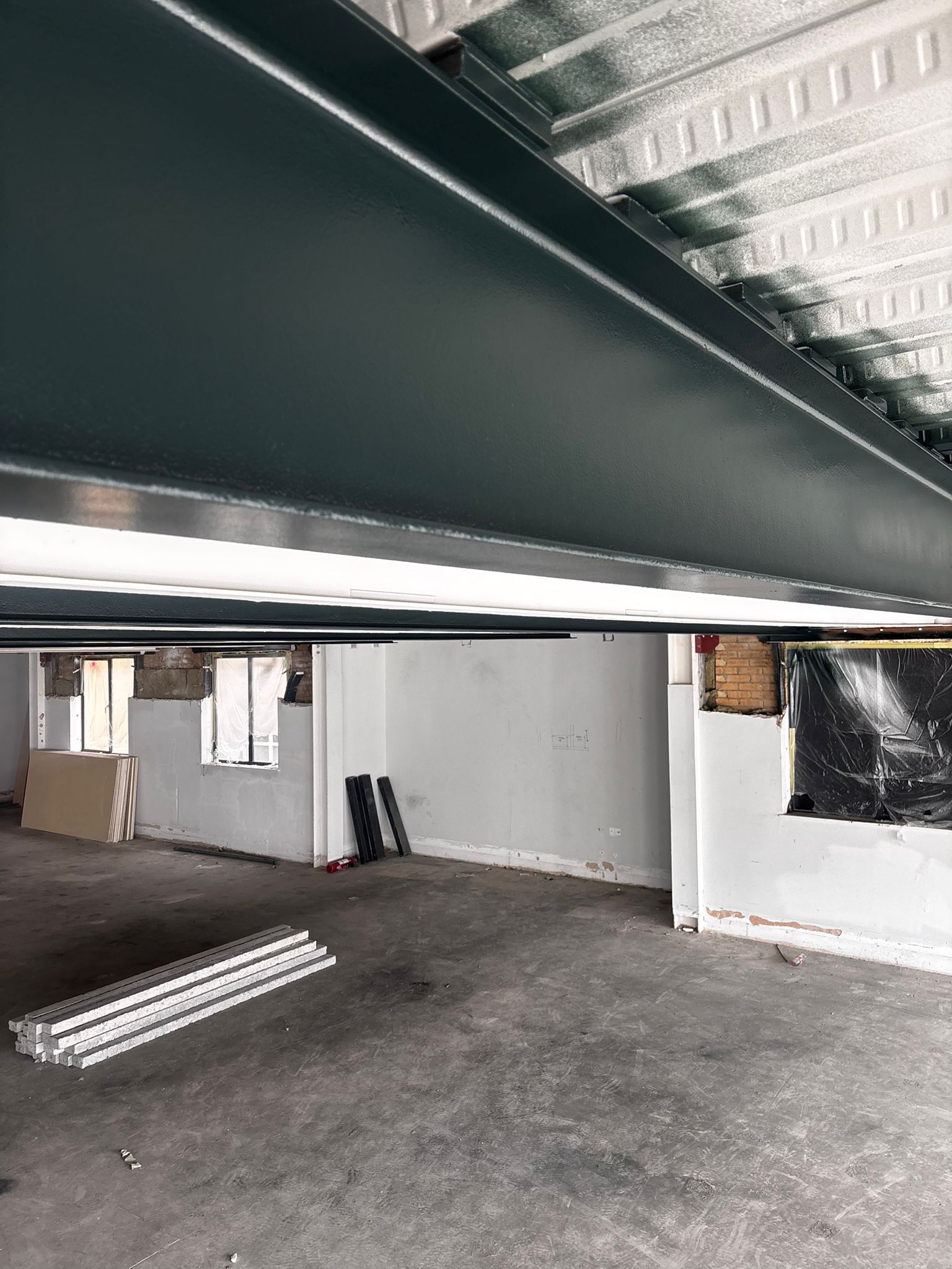 Finished dark intumescent paint on steel beam